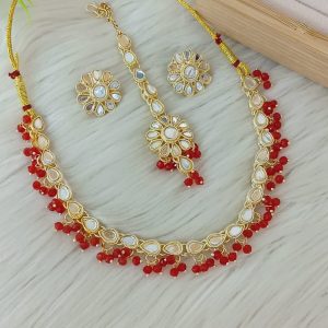 ndian-style antique Kundan jewellery set includes a necklace, earrings, and a maang tikka,