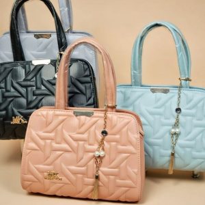 women’s satchel or top-handle handbags, featuring a distinct geometric quilted pattern and a small decorative tassel charm.