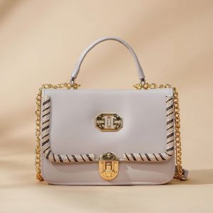 light-colored top-handle handbag with gold-tone hardware and chain details.